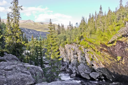 River of the beautiful waterfall Rjukandefossen with mountain and village views of Hemsedal, Buskerud, Norway.