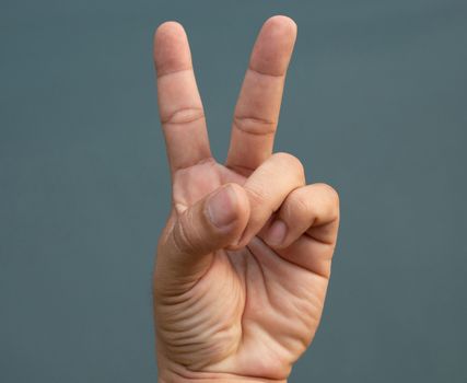 Two fingers raised on blue back ground. symbol concept.