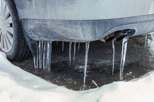 Icicles on exhaust of dirty car that was not used for some time, illustrating very low temperatures weather