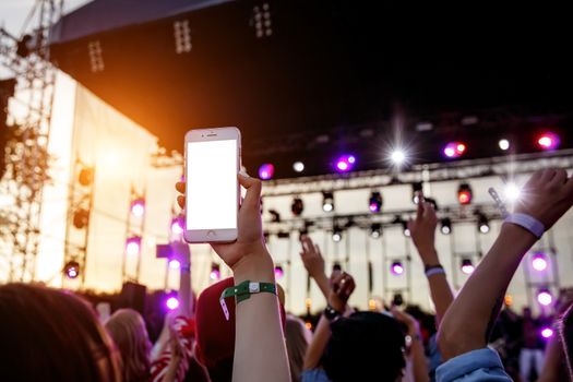 Live stream for social networks at a concert. Using a smartphone camera. White smartphone blank screen for your content.