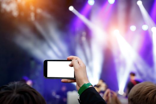 Live stream for social networks at a concert. Using a smartphone camera. White smartphone blank screen for your content.