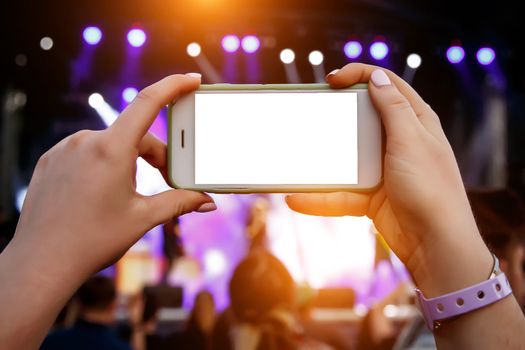 Live stream for social networks at a concert. Using a smartphone camera. White smartphone blank screen for your content.