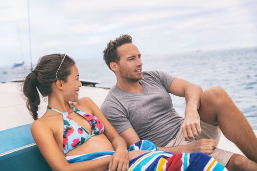 Yacht boat lifestyle couple talking on cruise ship in Hawaii holiday . Two tourists getaway enjoying summer vacation, woman relaxing in bikini.