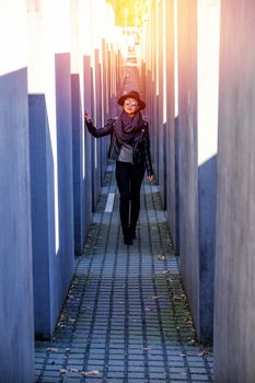 BERLIN, GERMANY - MARCH 26, 2017: Beautiful Young Asia Woman Tourist Walking at Holocaust Memorial to the Murdered Jews of Europe  in daylight at 26 March 2017, Berlin, Germany