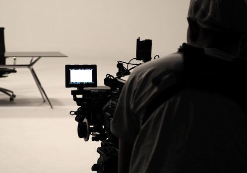 Behind the scenes or making of film in the studio and silhouette of camera man.