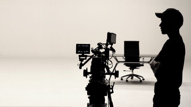 Behind the scenes or making of film in the studio and silhouette of camera man.