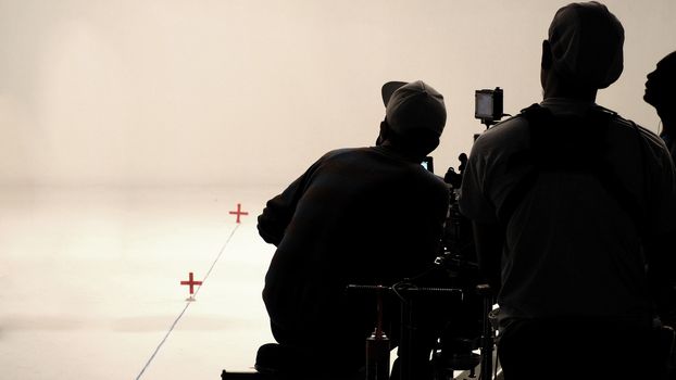 Behind the scenes or making of film in the studio and silhouette of camera man.