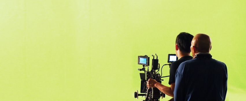 Camera and green screen studio in panorama view and man working or shooting or recording or filming.