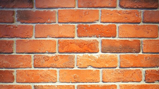 Red brick wall and old dirty rough surface texture close-up.