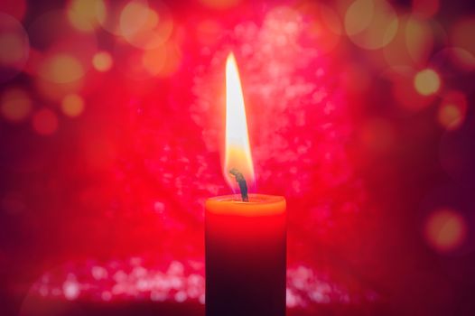 Single burning red candle conceptual of celebration, Christmas or Advent