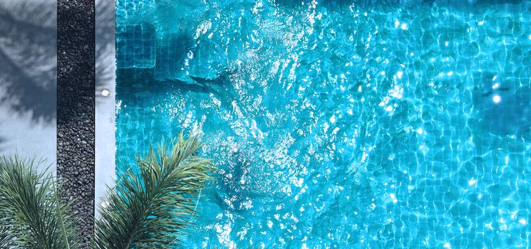 Swimming pool blue water in summer and white beach beds and top view angle.