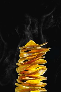 mexican nachos tortilla chips stack with smoke, black background