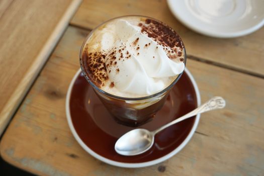 Spoon and cup of coffee on wooden table