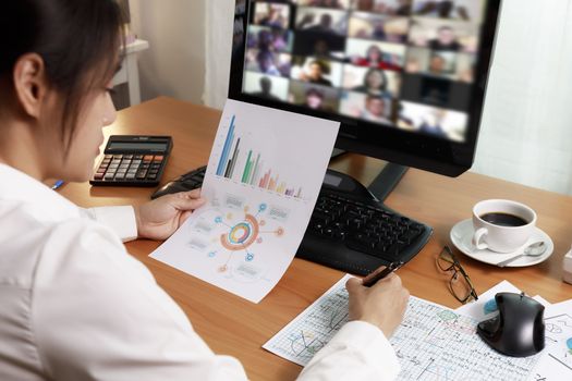 Asian business women working at home online meeting with video conference on computer. Business people using computer online meeting and speaking with team group.
