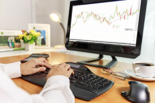 Business and financial concept  Hands of business women use PC computer trade stock market with candlestick chart on screen. Business women use computer network control trade buy and sell at home stock market.