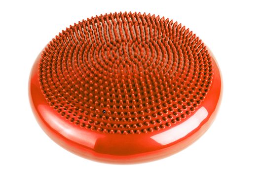 orange inflatable balance disk isoleated on white background. A balance disk is a cushion can be used in fitness training as the base for core, balance, and stretching exercises. It is also known as a stability disc, wobble disc, and balance cushion.