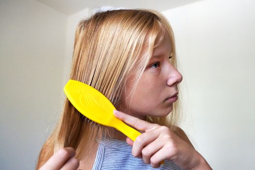 girl with long hair combing her hair.