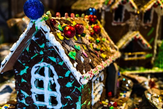 Colorful gingerbread house isolated on blurred background with Christmas decoration.