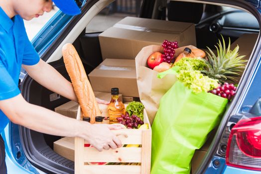 Asian delivery man grocery prepare service giving fresh vegetables food and fruit full in wooden basket on back car to send woman customer at door home after pandemic coronavirus, Back to new normal