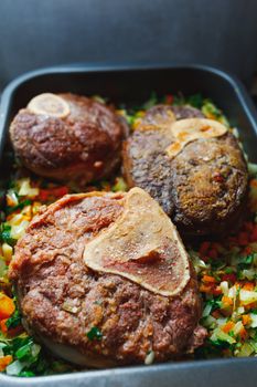 beef ossobuco meat on tray with crushed vegetables