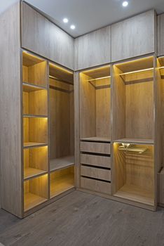 Interior design decor furnishing of luxury show home bedroom showing walk in wooden wardrobe closet furniture