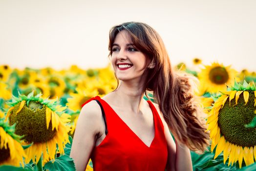 beautiful young woman in field of sunflowers.