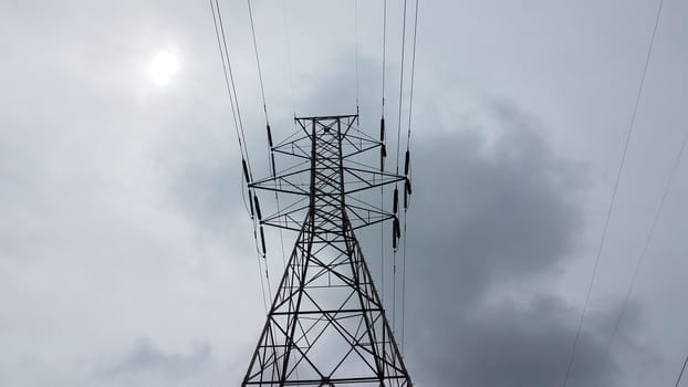 metal tower structure with power or electrical lines and clouds