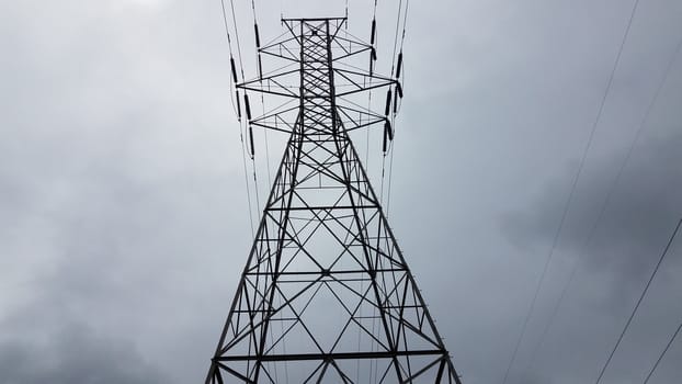 metal tower structure with power or electrical lines and clouds