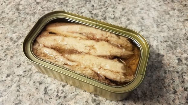 metal can of sardine fish with oil on counter