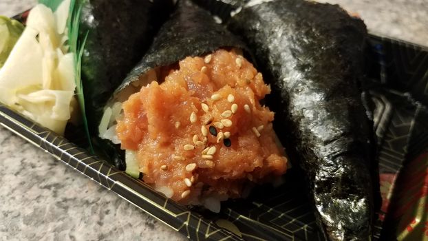 spicy tuna handroll sushi seafood with sesame seeds in container