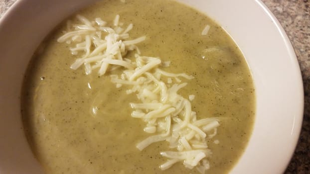 bowl of green zucchini soup with mozzarella cheese