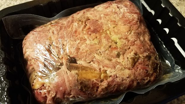 plastic bag of pulled pork meat in container