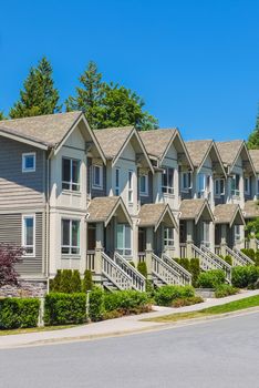 Brand new townhouses in a row on bright sunny day