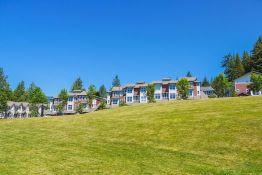 Row of new townhouses on top of the hill on sunny day in British Columbia