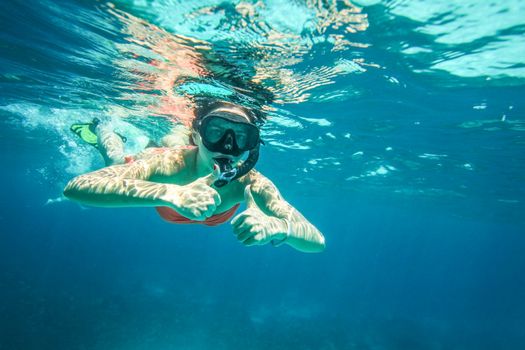 Young woman snorkel, holding two thumbs up, Similan Islands (Phang Nga), Thailand, one of the best snorkeling locations in Andaman sea. 