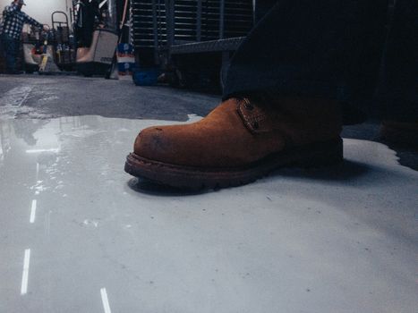 A Man Wearing a Leather Boot Stepping in Spilled Milk