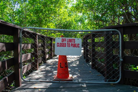 A Boardwalk With a Fenced Off Section With a Traffic Cone Behind It Stating That It's Off Limits to the Public