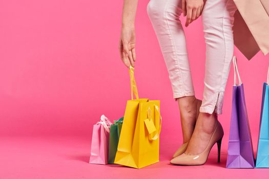 shopping bags female feet in shoes Shopaholic pink background. High quality photo