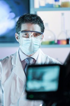 Laboratory hospital clinic doctor, scientist or exper, wearing protacive mask while addressing public in media interview explaining preventive measures against corona virus pandemic outbreak.