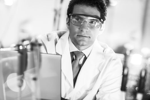 Portrait of a confident male engineer in his working environment. Science and technology concept. Black and white image.