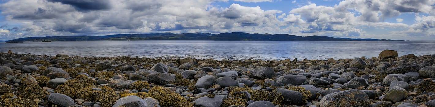 Panoramic view of rocks and boulders on the shore of the Firth of Clyde on the West coast of Scotland