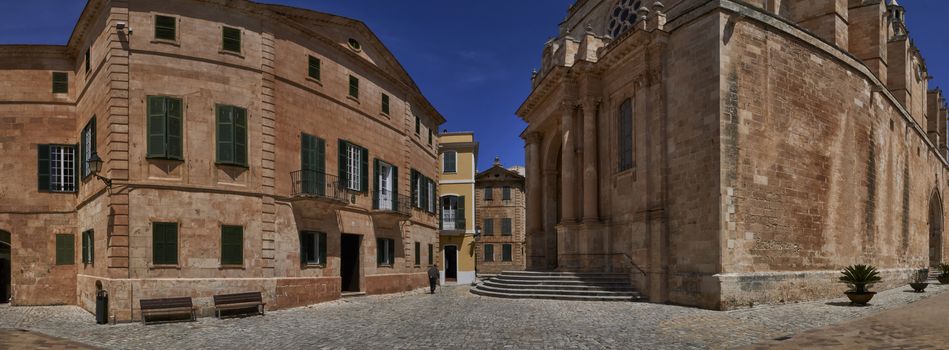 Panoramic view of old man with walking stick walking passed entrance to Cathedral in Ciutadella, Menorca