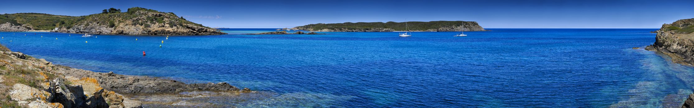 Panoramic view of secluded beaches in a bay of water in Menorca                               