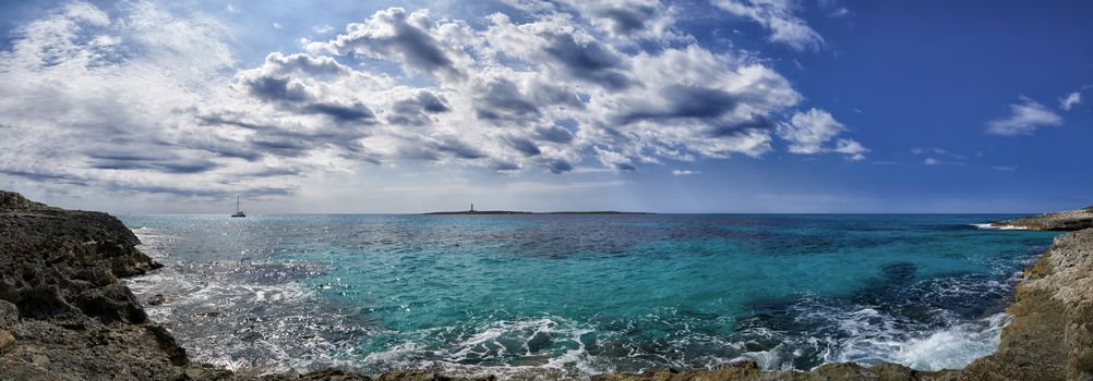 Panoramic view of lighthouse in Mediterranean sea off the coast of Menorca at Punta Prima