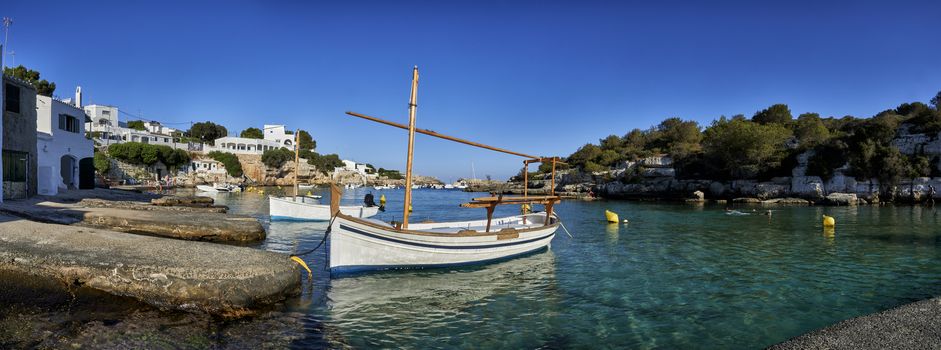 Panorama of small boats moored in the Mediterranean cove of Cala Alcaufar,Menorca,