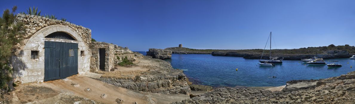 Panorama of small boats moored in the Mediterranean cove of Cala Alcaufar,Menorca,