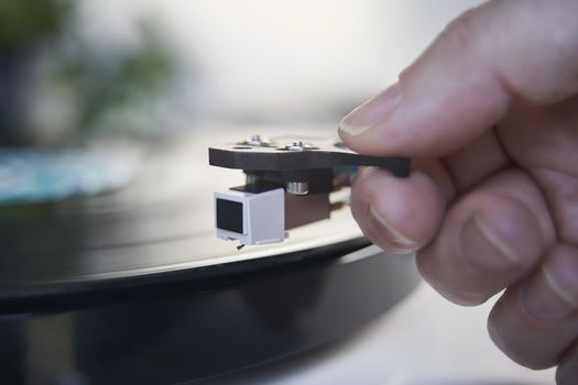 Close Up Of Hand Putting Needle Of Record Player Turntable On Vinyl LP
