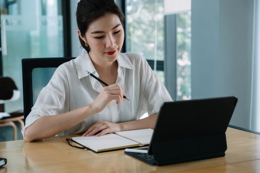 Woman using smart tablet for training online and writing lecture note. e-learning education concept.