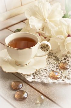 Bouquet of peonies, tea in white elegant cup, photo in gentle colors. have a nice day concept.