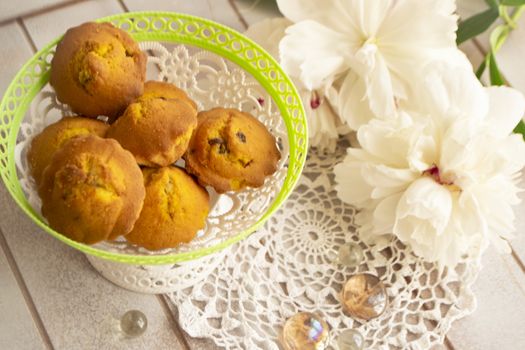 homemade muffins . Bakery products with white peony. tasty little cupcakes with flowers on wooden shabby table